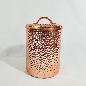 Rustic hammered copper and ceramic food storage container.